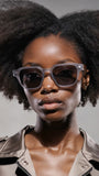 Woman wearing Pas Jalou sunglasses with a neutral background