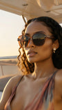 Woman wearing Pas Jalou sunglasses on a boat with a blurred background