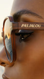Close-up of a person wearing Pas Jalou sunglasses with 'Pas Jalou' branding.
