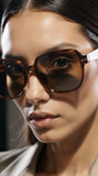 Close-up of a person wearing pas jalou sunglasses with a blurred background