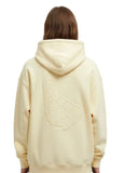 erson wearing a light yellow hoodie with a geometric embossed design of the map of barbados on the back of the sweater