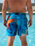 Person wearing colorful swim shorts by a pool