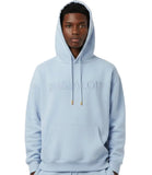 Person wearing a cream hoodie with 'PASJALOU' branding on a white background
