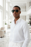 Man wearing a white shirt and pas jalou sunglasses in a modern indoor setting