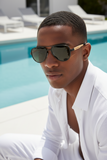 man lounging by the pool wearing pas jalou sunglasses in an all white outfit