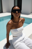 Woman in a white outfit and Pas jalou sunglasses by a pool
