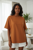 Woman wearing a brown t-shirt withembossed "pas jalou" text