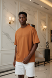 Man wearing an orange t-shirt with embossed "pas jalou" text