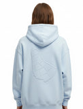 Person wearing a light blue hoodie with a geometric embossed design of the map of barbados on the back of the sweater